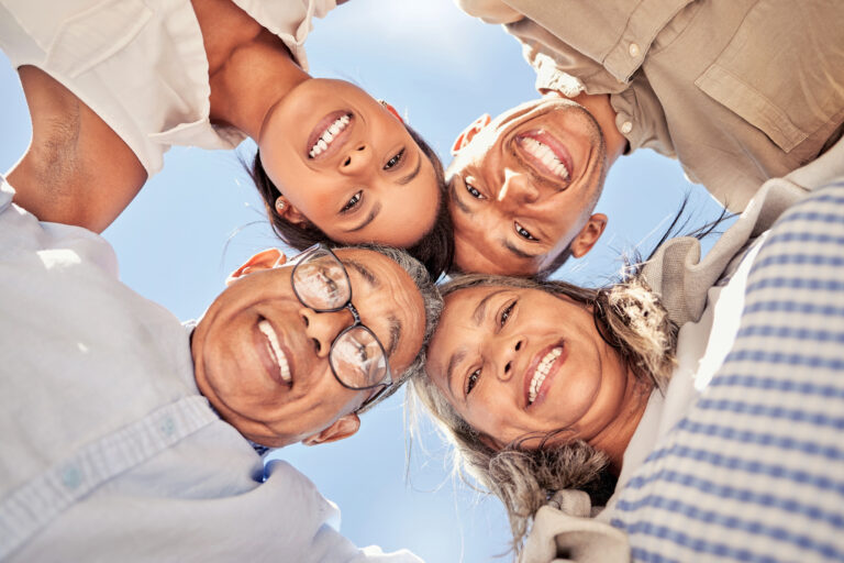 Portrait, huddle and family with smile for support, love and solidarity from below with blue sky. F.